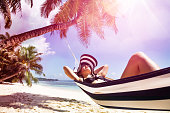 Young Woman Relaxing On Hammock Over The Beach