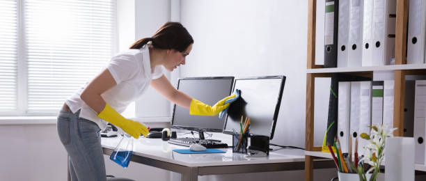 Woman Cleaning Computer In Office Young Woman Cleaning Computer With Rag In Office neat office stock pictures, royalty-free photos & images