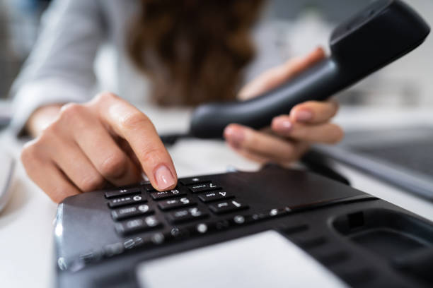 mujer empresaria llamando a la línea de teléfono - telephone dialing human hand office fotografías e imágenes de stock