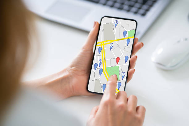 istock Woman's Hand Holding Mobile Phone With Location Mark On Map 1194077020