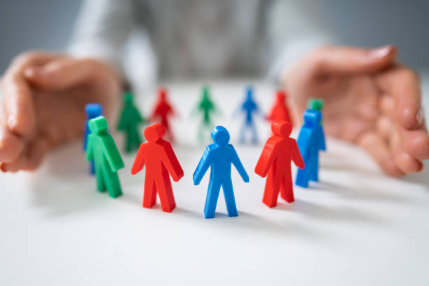 istock Person Protecting Multicolored Pawns 1194077295