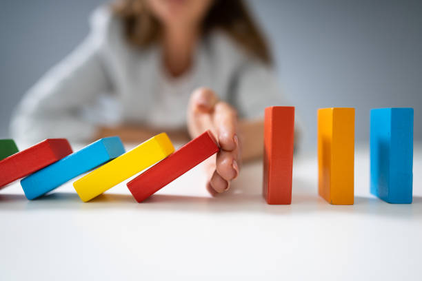 istock Businessperson Hand Stopping Colorful Blocks From Falling 1194077321
