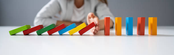 istock Businessperson Hand Stopping Colorful Blocks From Falling 1194077328