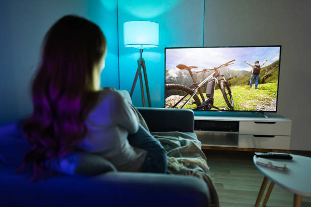 istock Woman Watching TV While Relaxing On Sofa 1194077331