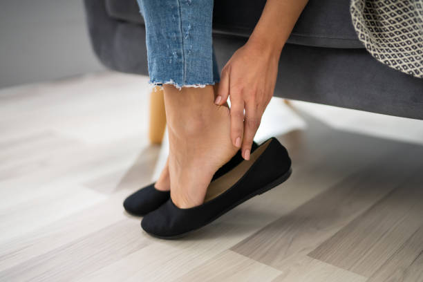 Woman's Hand Removing Uncomfortable Ballerinas Close-up Of Woman's Hand Sitting On Sofa Removing  Uncomfortable Ballerinas ballet dancer feet stock pictures, royalty-free photos & images