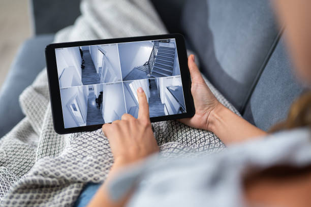 istock Woman Looking At CCTV Camera Footage On Digital Tablet 1194078043