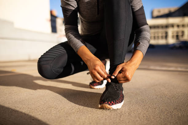 Female runner tying her shoes preparing for a run
