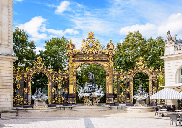 The fountain of Neptune on the place Stanislas in Nancy, France. The fountain of Neptune in the Rococo style and the gilded wrought iron portico in the north-west corner of the place Stanislas in Nancy, France. neptune roman god stock pictures, royalty-free photos & images