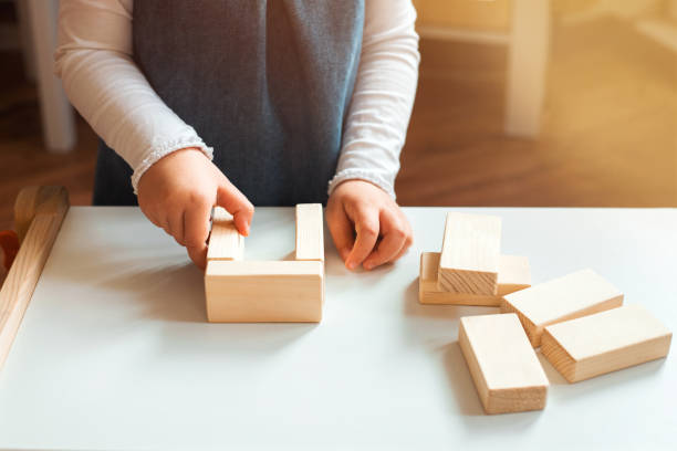 istock Little girl playing with wooden bricks at home. 1194090465