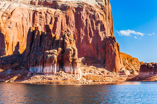 Azure water of Lake Powell among the rocks of Monument Valley. Grandiose cliffs - red sandstone outcroppings. The border of the states of Utah and Arizona. Concept of active and photo tourism