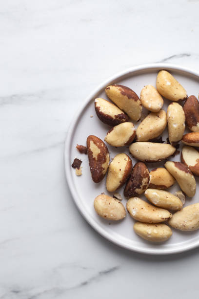 brazil nuts on white marble background - chestnut food nut fruit imagens e fotografias de stock