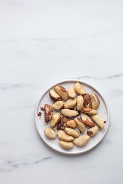 istock Brazil nuts on white marble background 1194091355