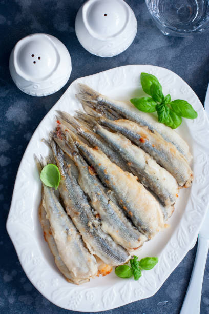 istock Whole grilled smelt fish on a white dish, selective focus, top view 1194092815