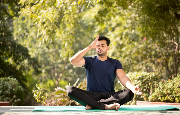Handsome young man practicing yoga at park Handsome young man practicing yoga at park Yoga    stock pictures, royalty-free photos & images