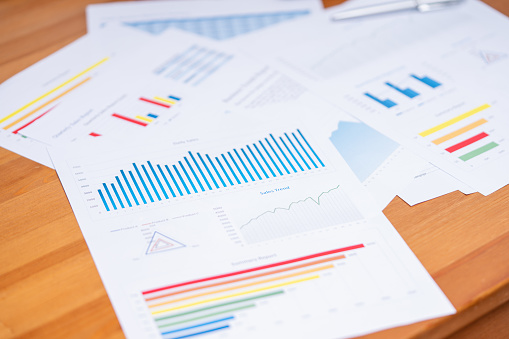 Business report with variety of graphs and charts on desk. Business and finance background concept.