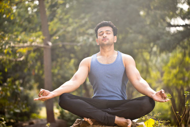 istock Man meditating at park 1194095299