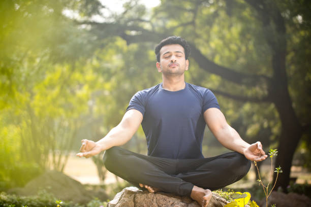 istock Man meditating at park 1194095318