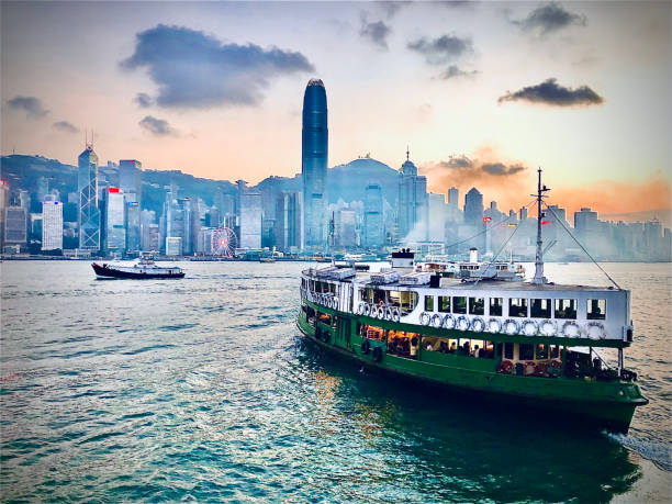 coucher du soleil et le ferry d'étoile dans le port de victoria, hongkong - ferry photos et images de collection