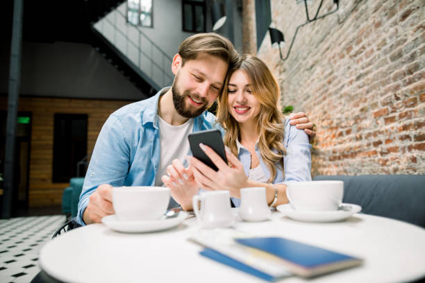 istock Getting ready for the trip with a coffee. Happy couple sitting at the table, drinking coffe or tea, using phone. Passports and tickets on the table 1194100567