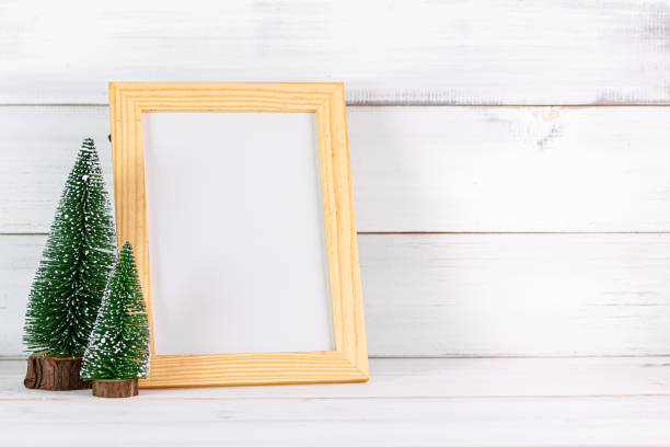 istock Pine tree and empty photo frame on white wood background with copy space 1194101350