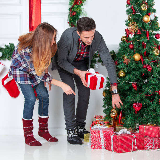 istock Parents put christmas gifts under tree 1194105707