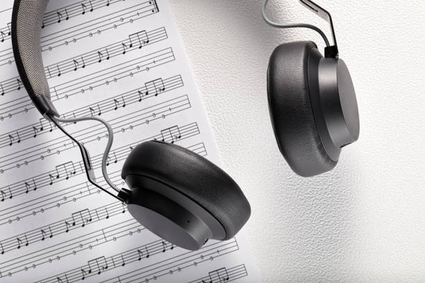 istock Black professional headphones on sheet music with copy space 1194109301