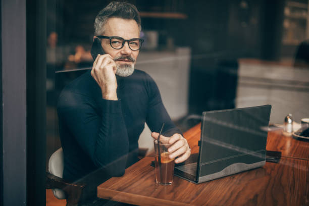 istock Mature man using phone in the coffee shop 1194110207