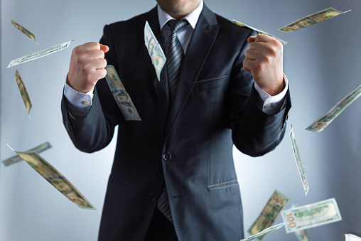 Winning businessman in rain of dollar banknotes