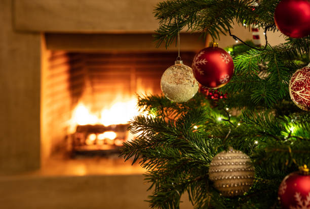 istock Christmas tree close up on burning fireplace background 1194110614