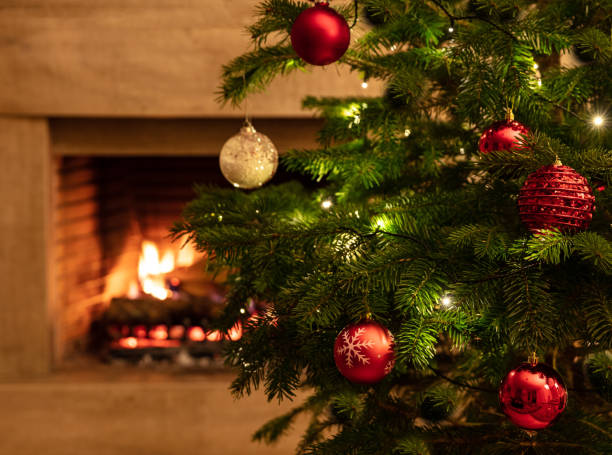 istock Christmas tree close up on burning fireplace background 1194110617