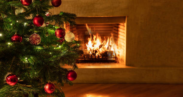 istock Christmas tree close up on burning fireplace background 1194110622