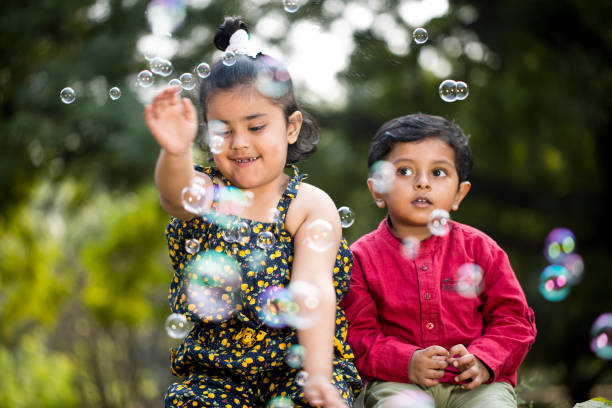 istock Children blowing bubbles at park 1194111463