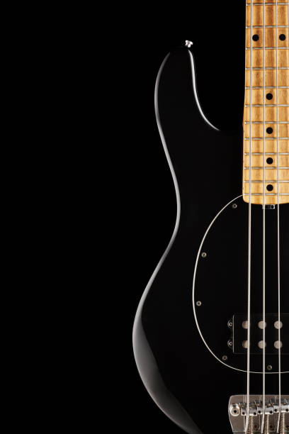 istock Black electric bass guitar on black background 1194112875