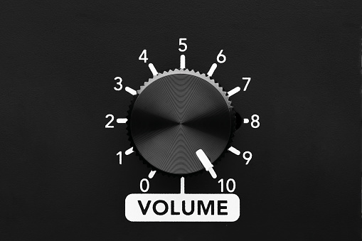 Volume control knob of a black amplifier on maximum loudness. Close up view with copy space.