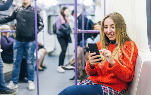 istock Young woman texting in the subway train 1194115105