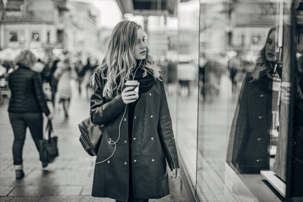 istock Young woman is looking at shop window 1194115126