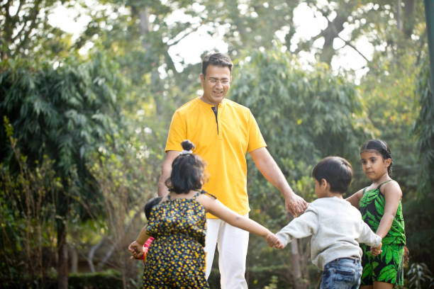 istock Father with children playing together at park 1194115241