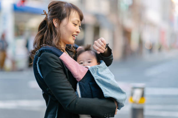 彼女の赤ちゃんの女の子と一緒に通勤する母 - 日常の一コマ ストックフォトと画像