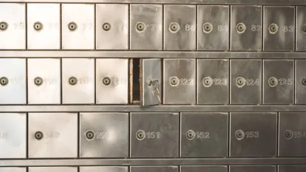 Half opened silver steel post office box (P.O. BOX) with keys inside the lock