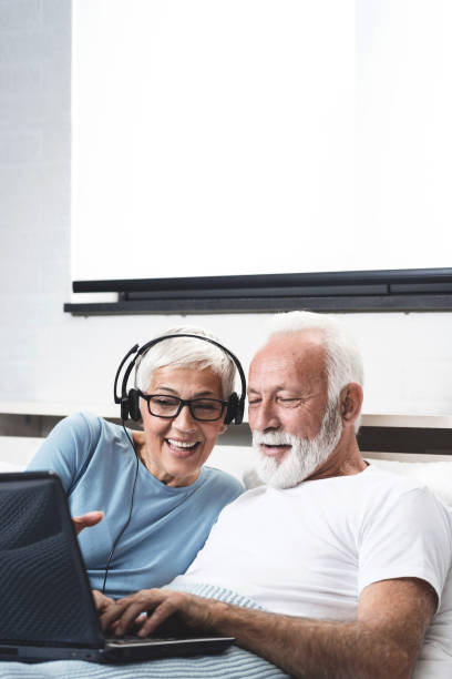 Elderly retired couple talking over the camera, skype call