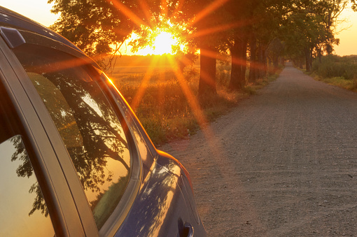 the sunset and the car, the sun's rays blue cars on the road