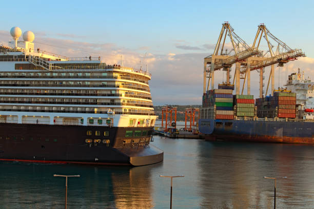 The process of mooring huge luxury cruise ship in the harbor. Autumn morning landscape. Container ship loading by containers in the background Koper, Slovenia-September 29, 2019: The process of mooring huge luxury cruise ship in the harbor. Autumn morning landscape. Container ship loading by containers in the background. International water transport koper slovenia stock pictures, royalty-free photos & images