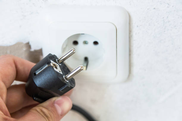 istock Close-up of a hand sticks an electrical plug into the socket. 1194122109