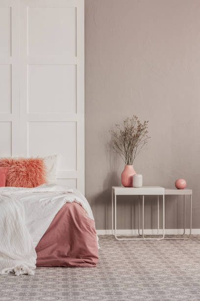 istock Copy space on grey wall of elegant bedroom interior with white table and king size bed 1194124448