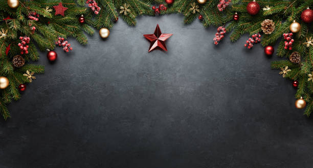 Christmas Star on black New Year banner. Xmas presents with decoration and fir branches on black background. stock photo