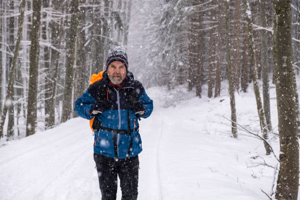 istock Man hiking in snowy forest 1194126624
