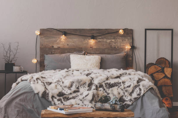 istock Warm duvet on comfortable bed with rustic headboard with lights 1194127481
