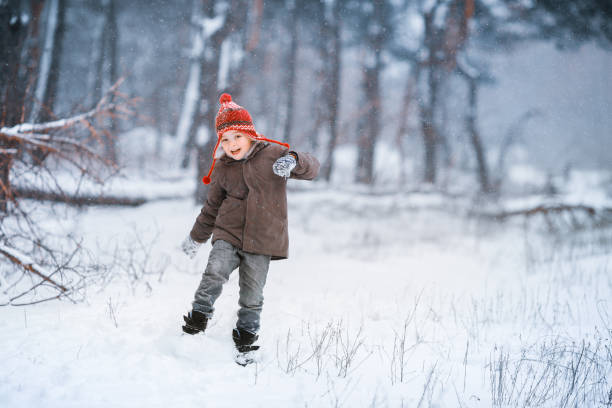 istock A boy walks in a snow-covered glade and having fun in the snow 1194128700