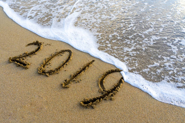 '2019' geschrieben auf dem sandstrand waschen weg durch meereswelle, ende des jahres konzept. - time month rear view calendar stock-fotos und bilder