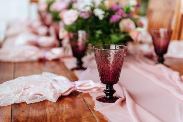 Vintage festive table setting with pink roses, candles and cutlery